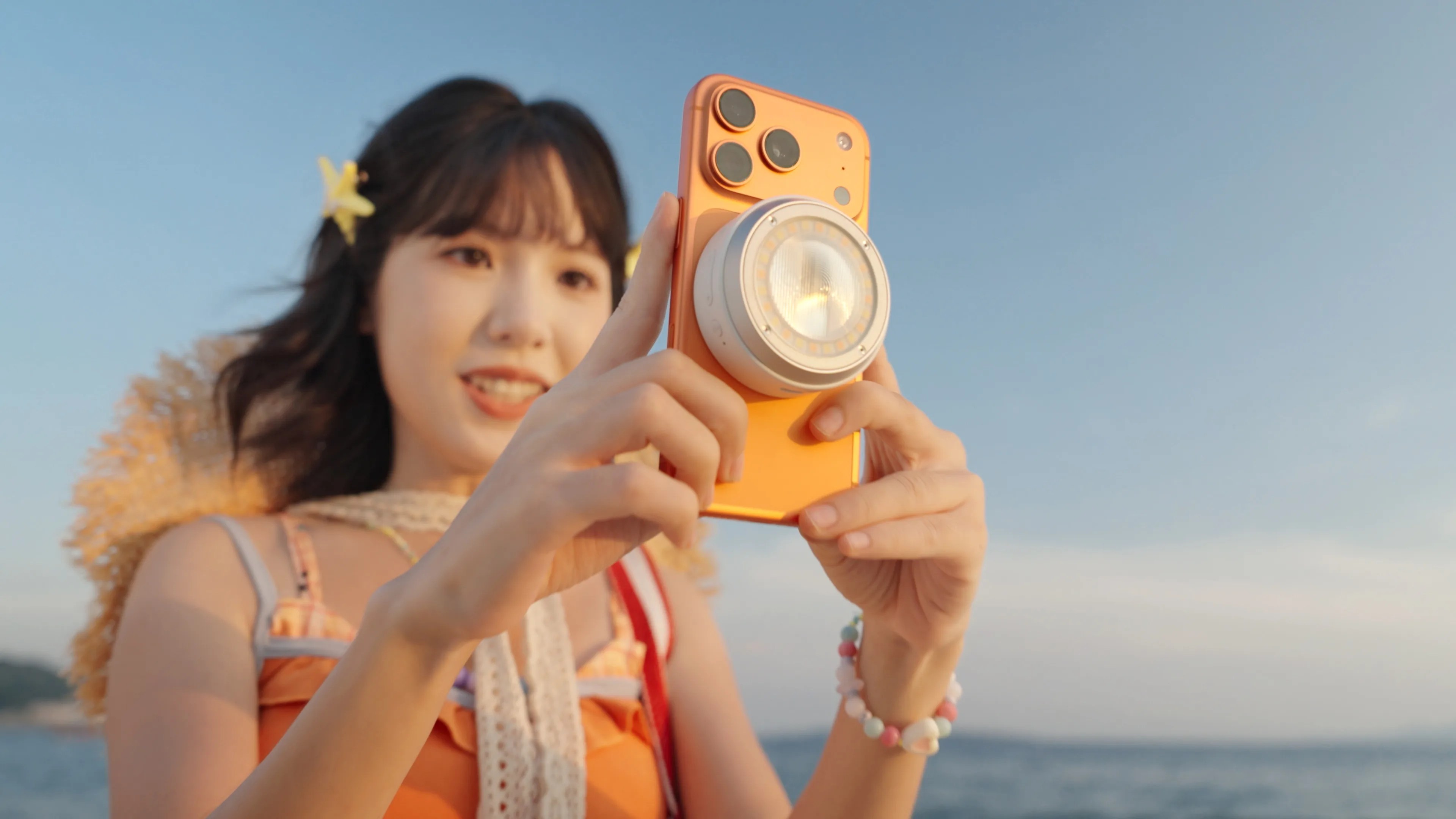 Godox promotional photograph of the A2 smartphone xenon flash attached to an orange iPhone